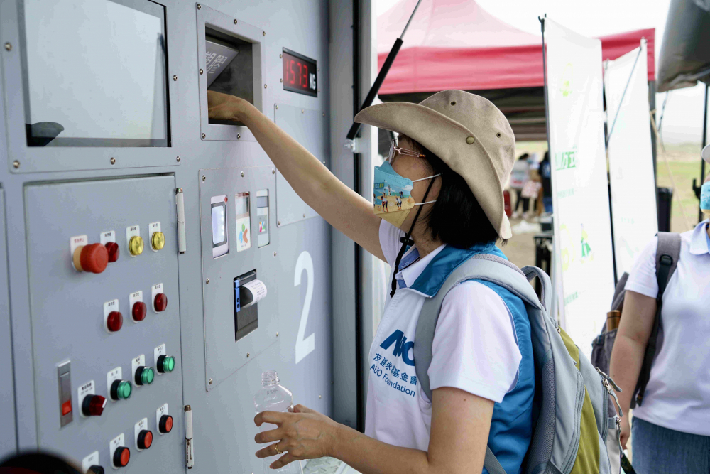 志工們將拾起的寶特瓶投入「好歸塑專車」，讓廢棄塑料空瓶可以直接粉碎、縮小體積，未來將可再製成購物袋、寶特衣、悠遊卡等生活用品